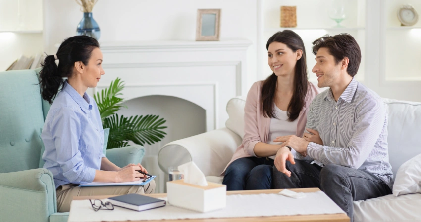 Image of a couple speaking with an addiction counselor in a calm recovery setting